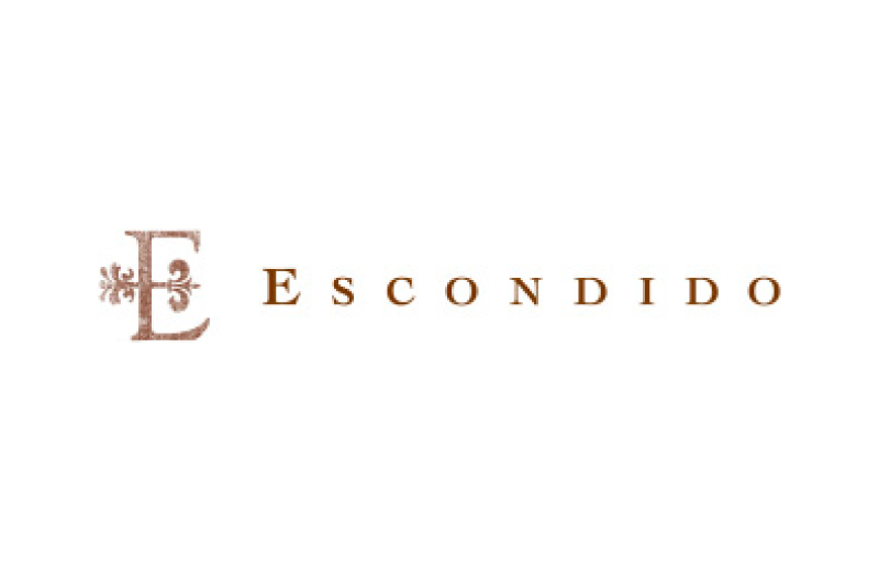 The image shows the word ESCONDIDO in brown capital letters, with a decorative letter E featuring a fleur-de-lis design to the left of the text on a white background, evoking the refined style of Escondido Golf Club.