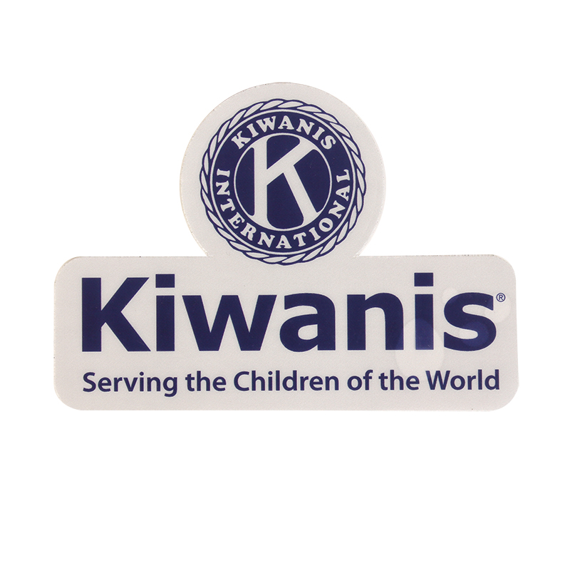 A sign featuring the Kiwanis International logo above the word Kiwanis and the slogan Serving the Children of the World in blue text on a white background.
