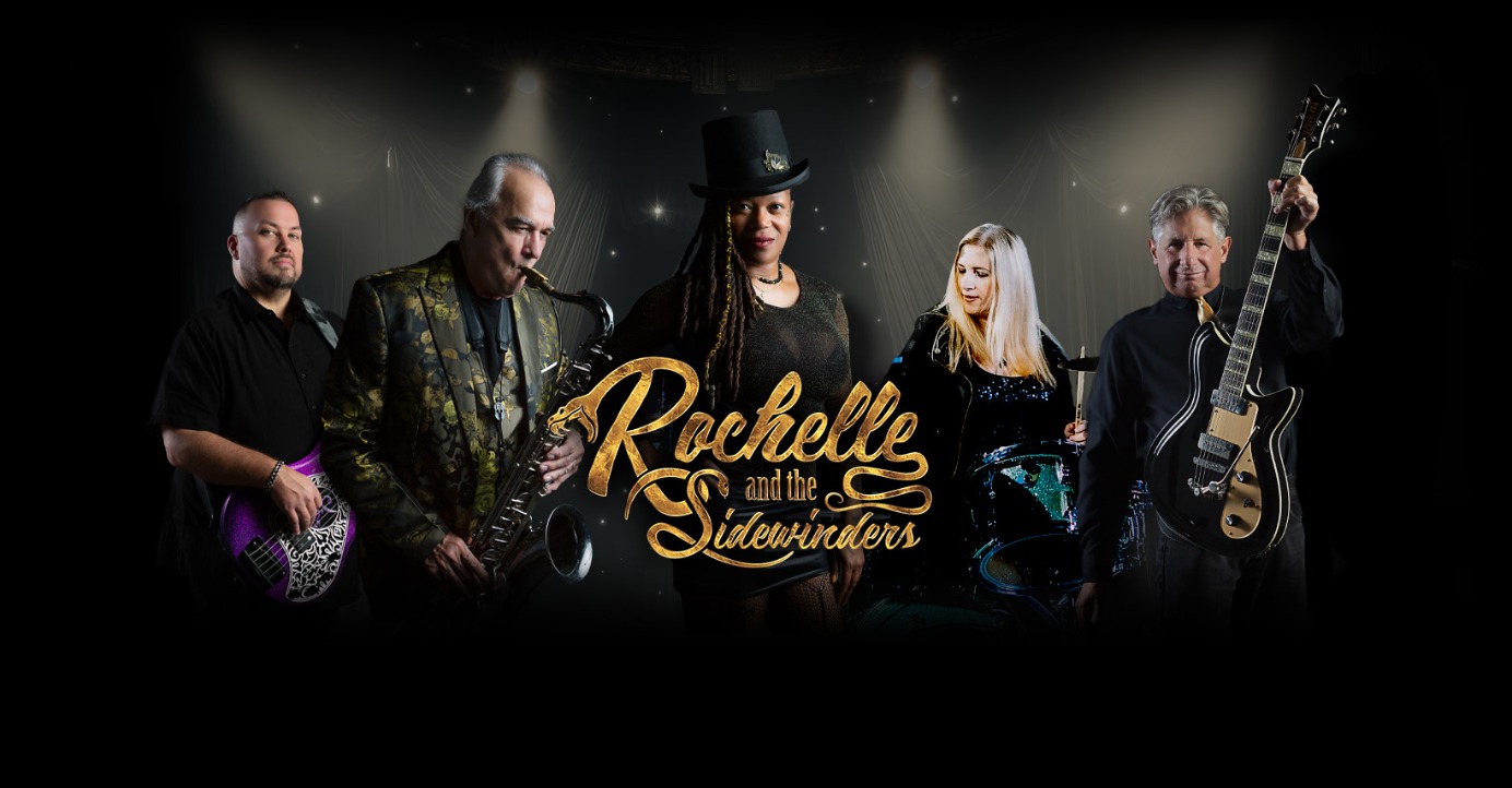 Five musicians pose with instruments against a dark background. The central figure wears a black top hat. Gold text reads Rochelle and the Sidewinders. Stage lights softly illuminate behind them.
