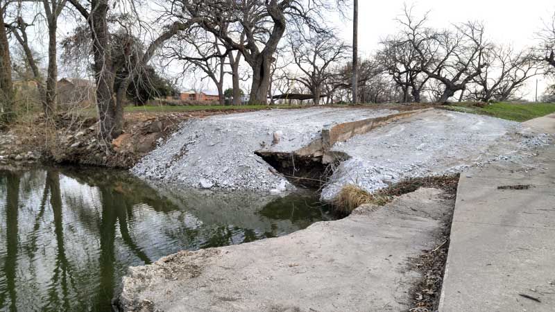 The city of Marble Falls parks and recreation and street departments combined efforts to repair damage done near the Johnson Park bridge over Backbone Creek on Feb. 6-7. Parks and recreation workers cleared out the area so street department members could use heavy equipment to place rock and pack it into place. Staff photo by Jennifer Fierro