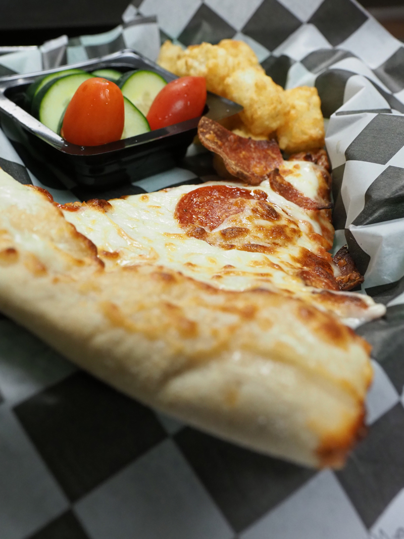 Kids can get a slice of pizza along with fresh vegetables and tater tots at The Eatery, part of the Burnet school district’s summer lunch program. Staff photo by Daniel Clifton